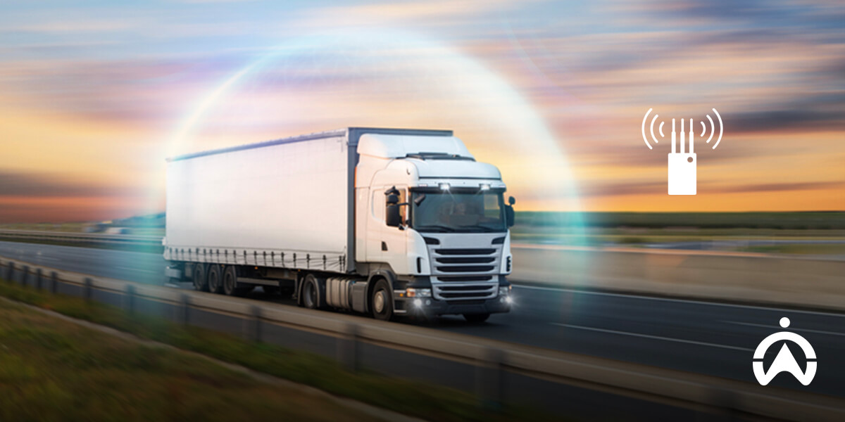 A white truck drives swiftly on a highway, surrounded by a digital communication signal, symbolizing connectivity and technology in logistics.