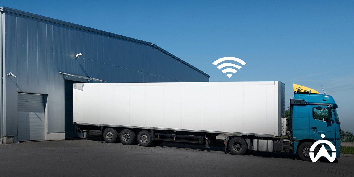Blue truck at warehouse with Wi-Fi symbol showing IoT tracking devices enabling connected loading operations.