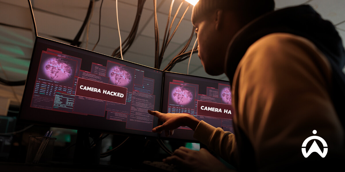 Cartrack system alert showing a dashcam hack warning on dual monitors with data streams and a world map.