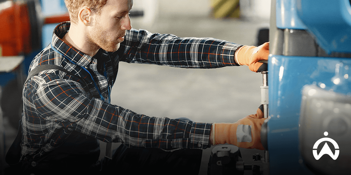 Worker repairing vehicle in garage as part of predictive maintenance.