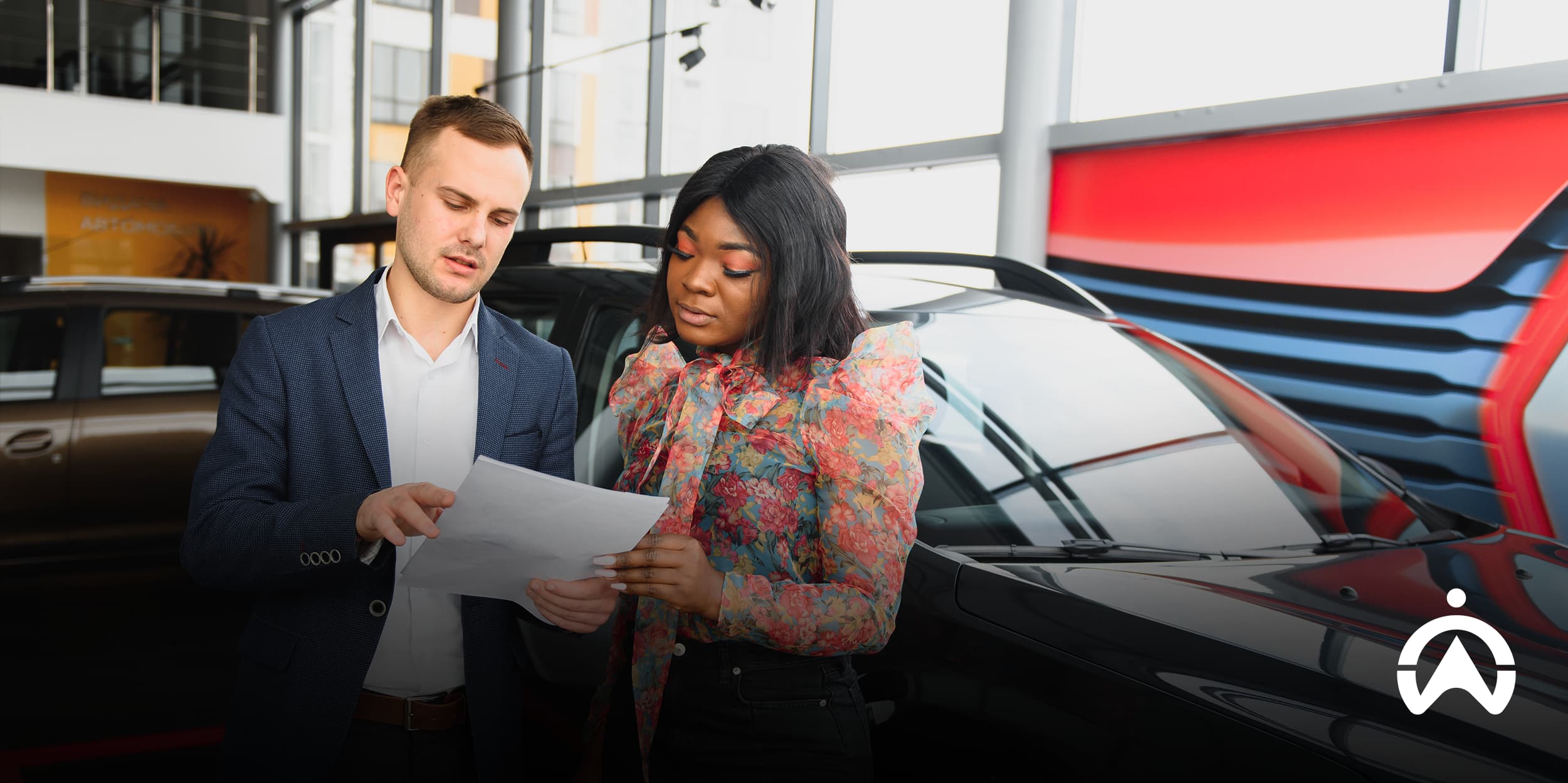 Buyer reviewing documents with dealer to assess what to look for when buying a second-hand car.