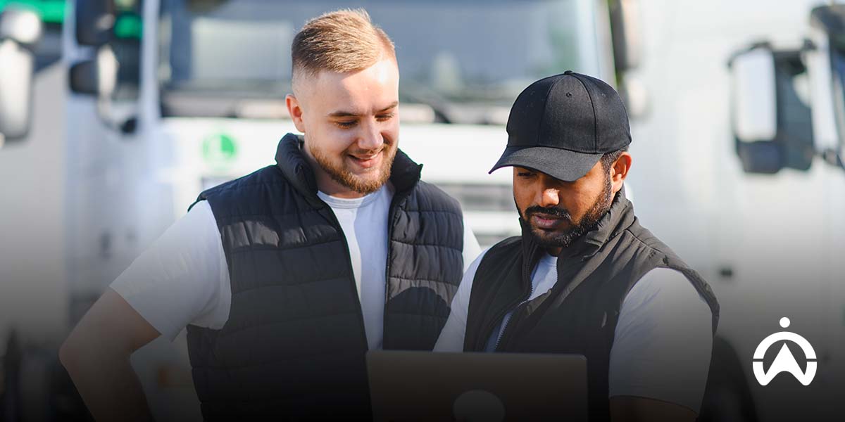 Team reviewing fleet data beside vehicles to support fleet optimisation.