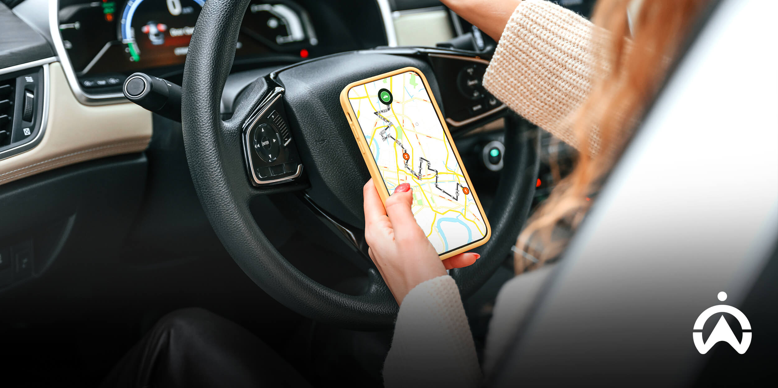 Person holding a smartphone with Cartrack app showing map connected to a GPS tracker with a camera for a car.