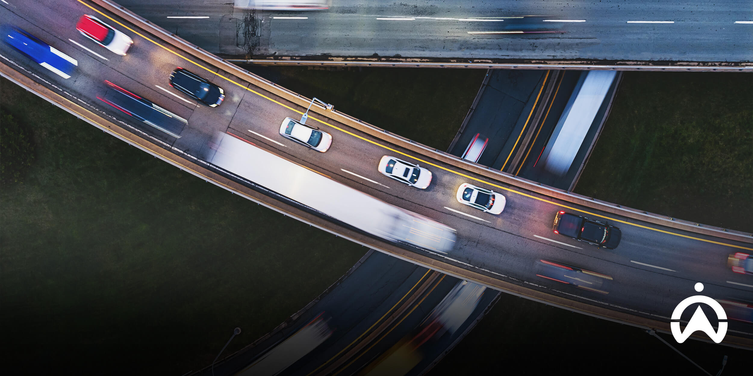 Aerial view of busy highway overpasses with moving vehicles, showcasing vibrant traffic patterns and road structures.