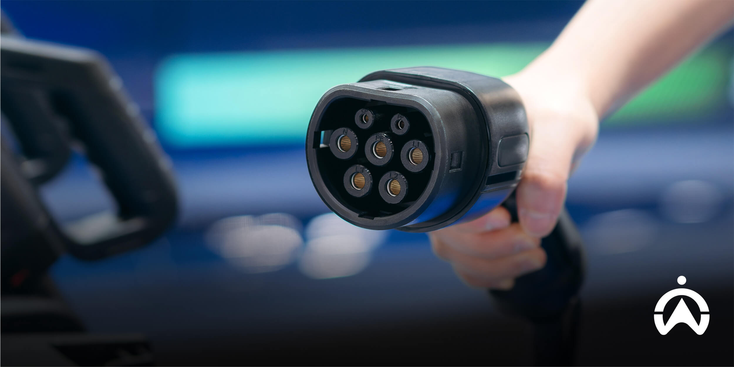 Hand holding EV charging connector supporting electrification of the last-mile.