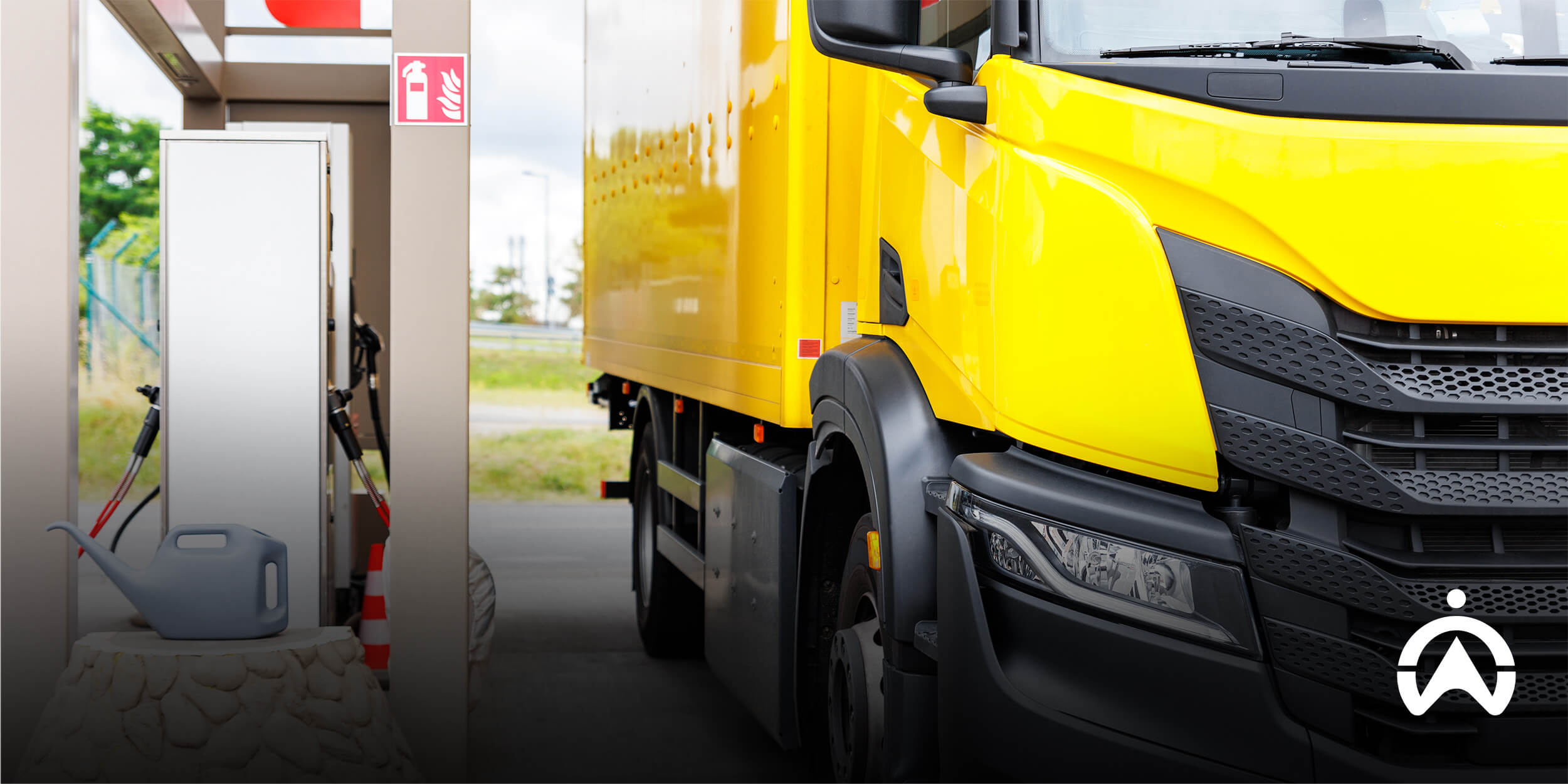 Yellow delivery truck refuelling at station, illustrating practical strategies for fuel reduction in fleet operations.