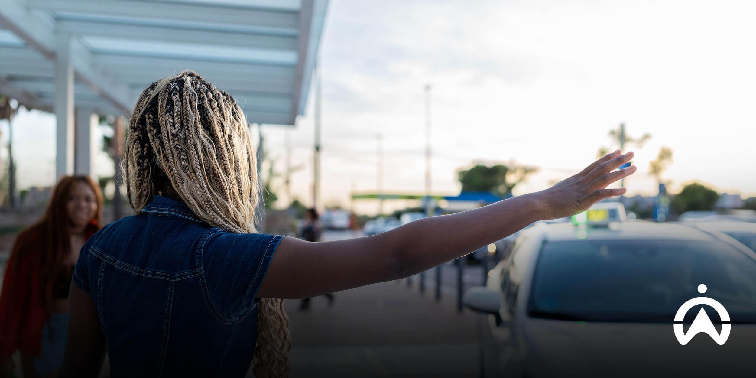 Person hailing a ride on city street at sunset, reflecting new rules for e-hailing in South Africa.