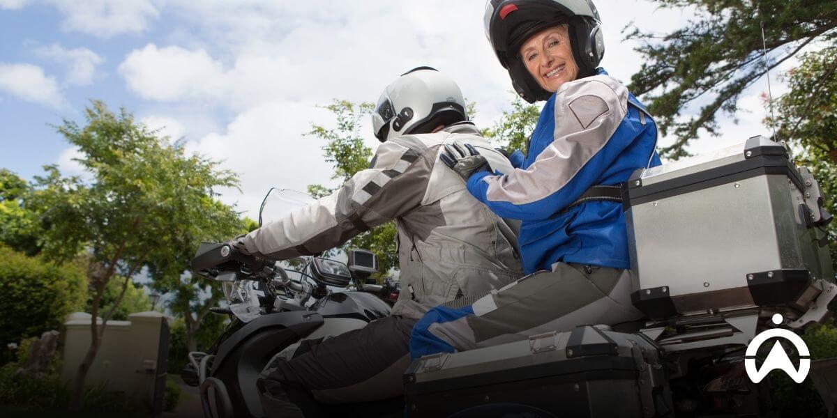 Two motorcyclists riding a touring motorcycle on a clear day, illustrating bike sharing software used for managing shared mobility and rental bikes