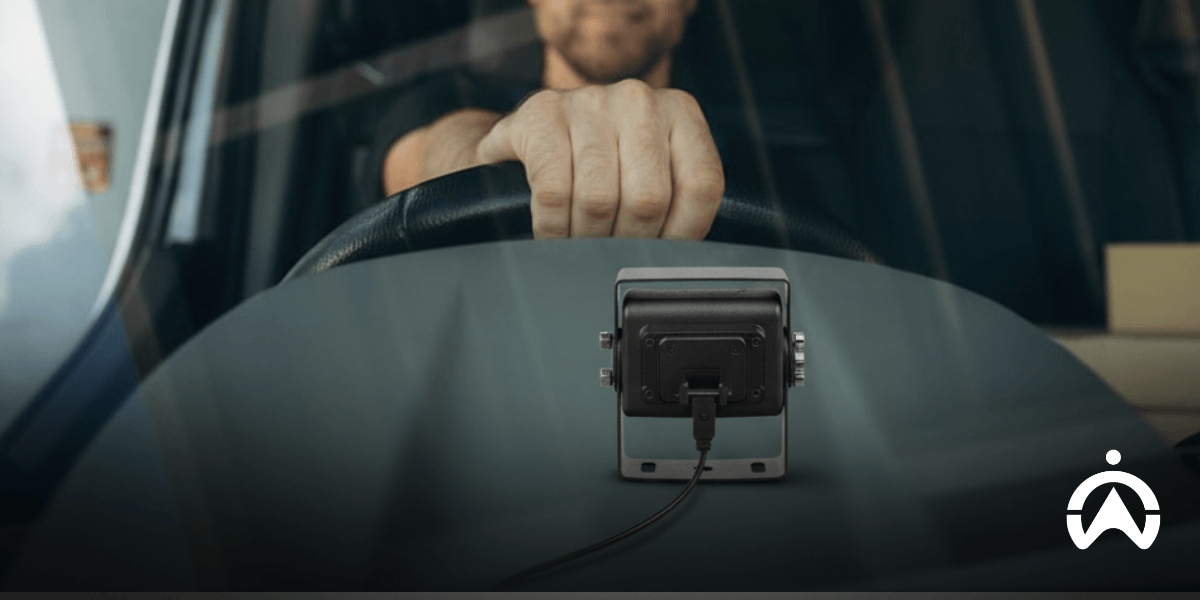 Driver using a dashboard camera and GPS device, illustrating how a dashcam can reduce insurance through safer driving and vehicle monitoring