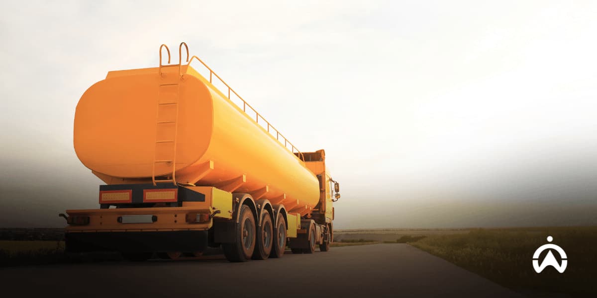 Orange tanker truck parked on a rural road, representing fuel hedging strategies and logistics for your business.