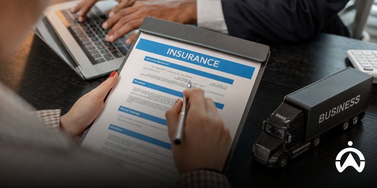 Person signing fleet insurance documents, showing how to reduce fleet insurance risk profile through effective risk management.
