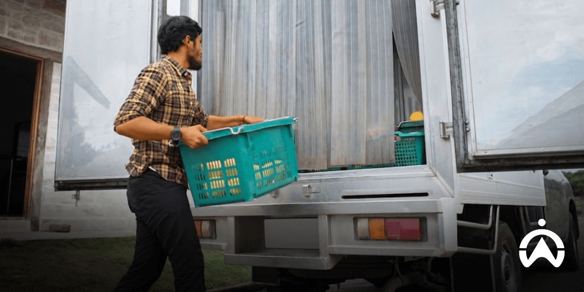 Worker loading a refrigerated delivery truck, highlighting the importance of detecting cold chain compressor fails before goods spoil.