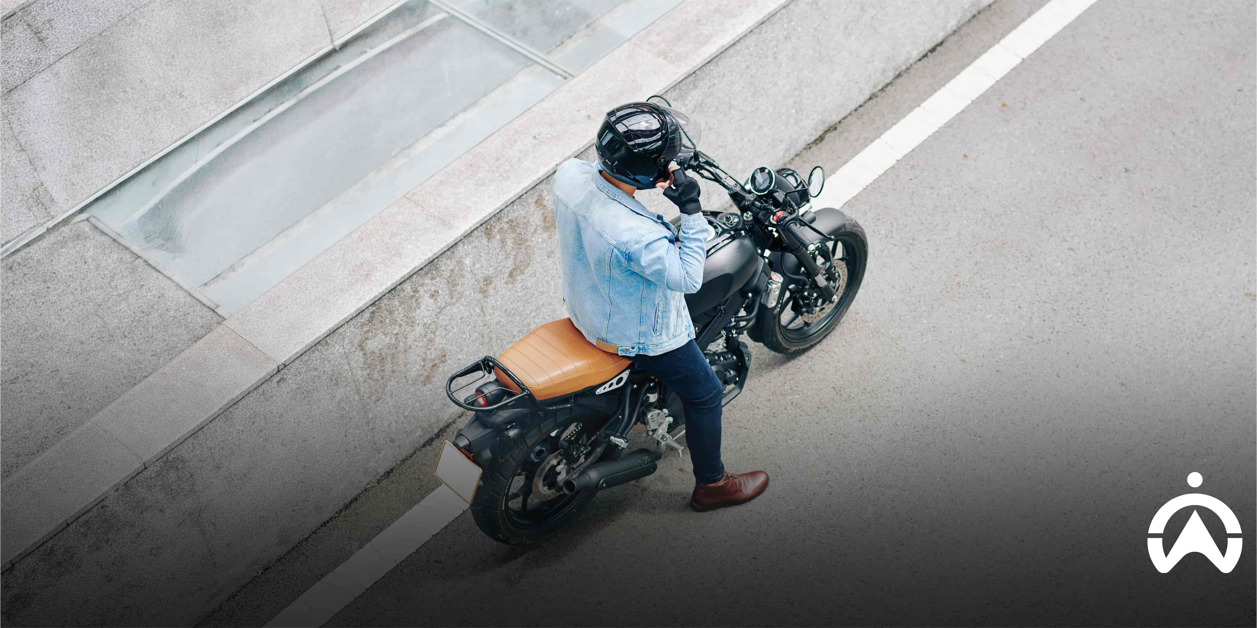 Motorcyclist parked roadside, comparing subscription vs no subscription tracking device for motorcycle security.