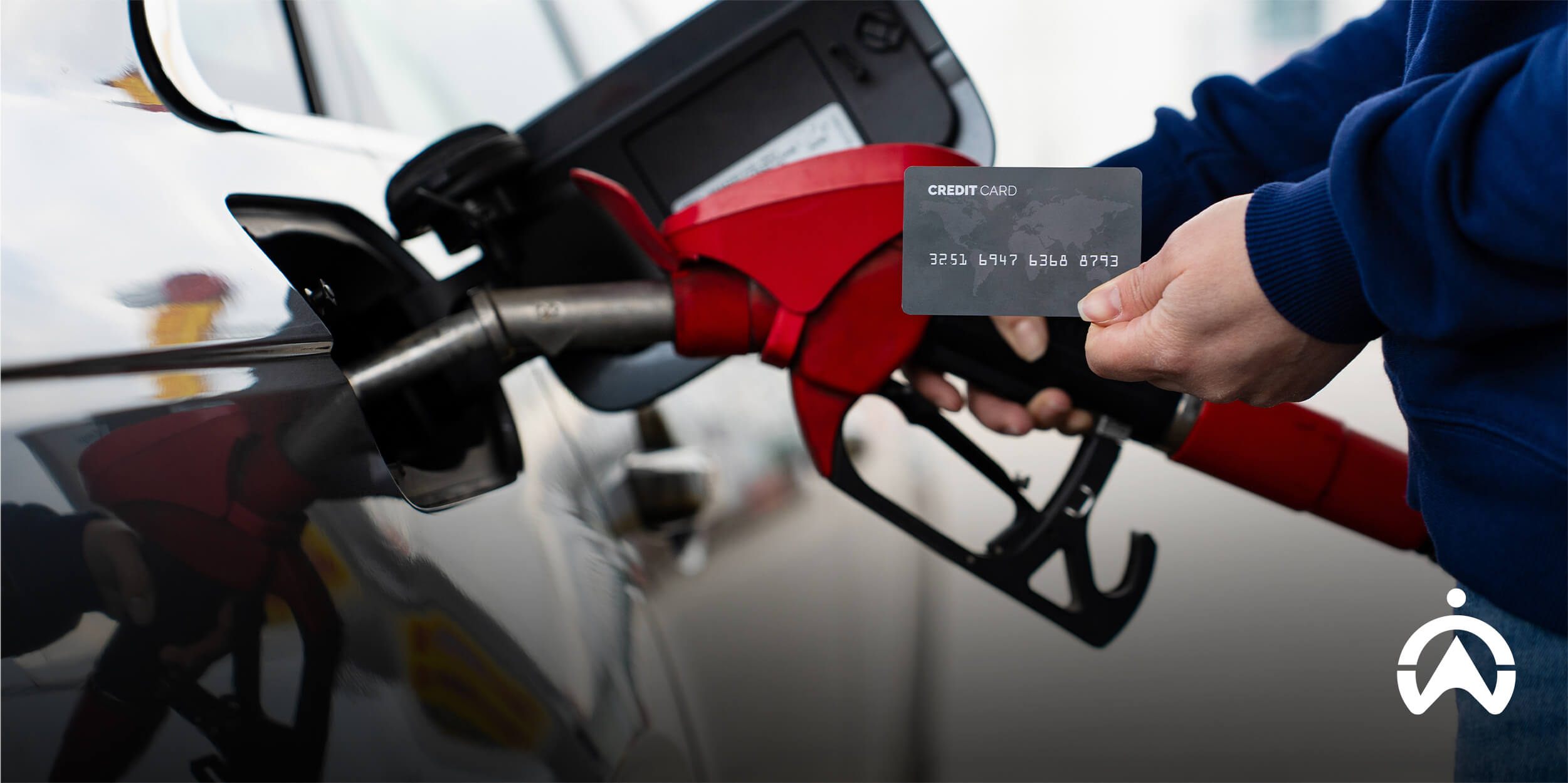 Driver using a fuel card at a petrol station, illustrating Fleet Fuel Card Integration for streamlined fuel payments.