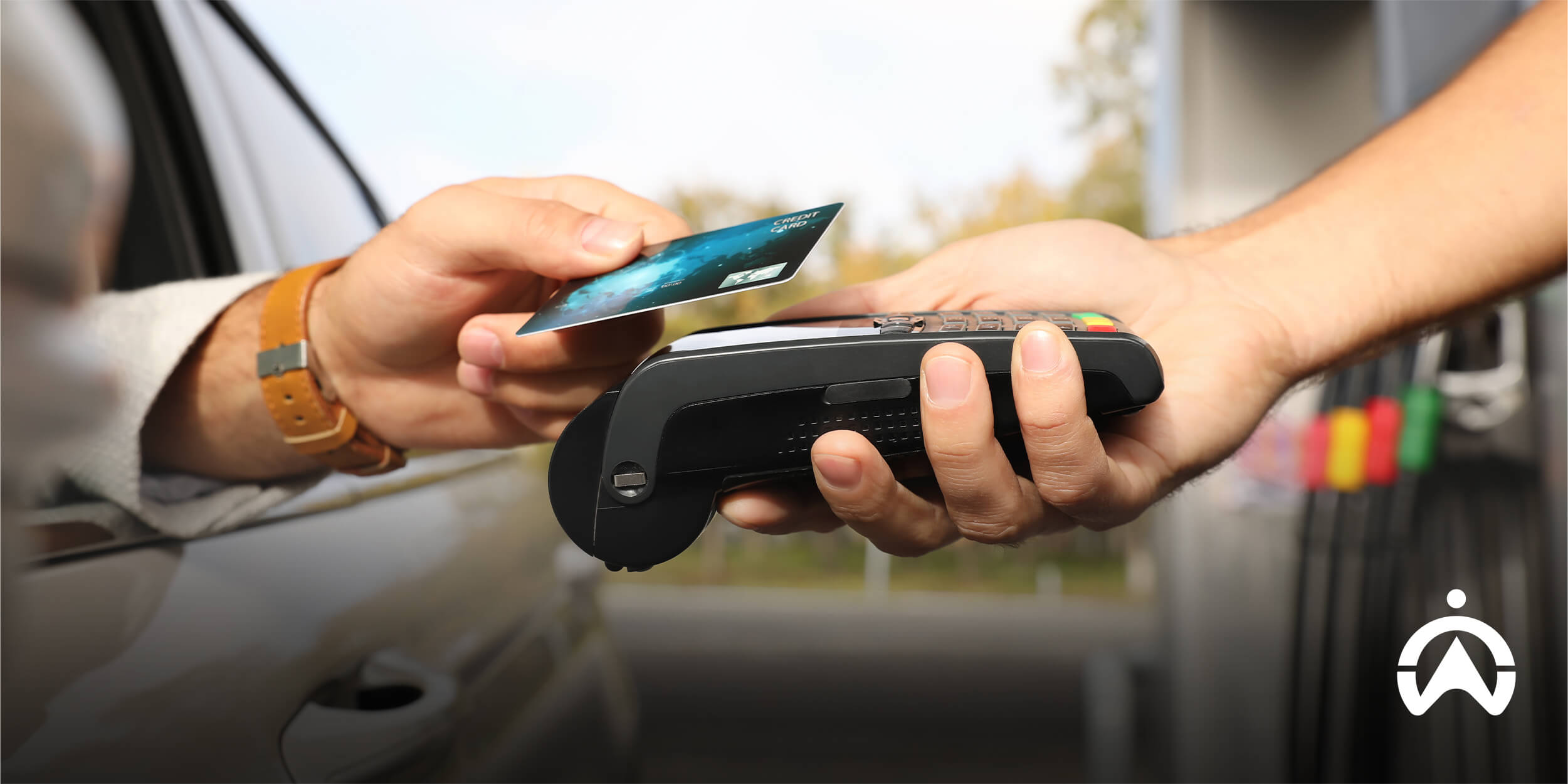 Driver using a contactless card reader for fleet fuel card integration at a gas station.
