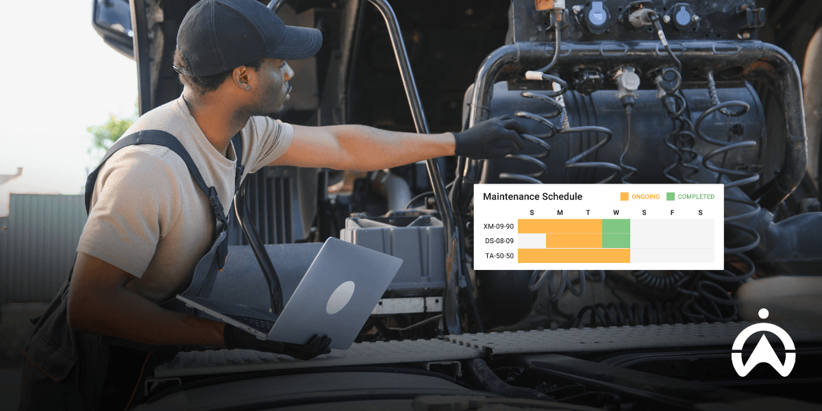 Mechanic using a laptop for Cartrack vehicle maintenance scheduling to reduce vehicle maintenance costs.