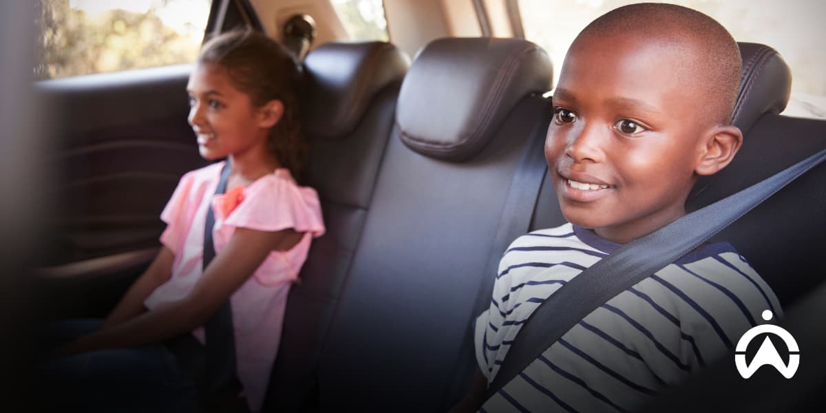 Children safely buckled in the back seat of a car, illustrating how to keep your child safe in a hijacking.
