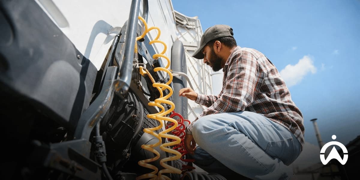 Mechanic inspecting truck air hoses and equipment to assess maintenance needs and avoid overservicing trucks.