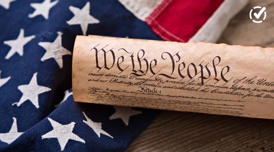 "A close-up of a rolled-up replica of the U.S. Constitution, featuring the prominent 'We the People' heading, resting on an American flag. The Formative by Newsela logo is in the top right corner."