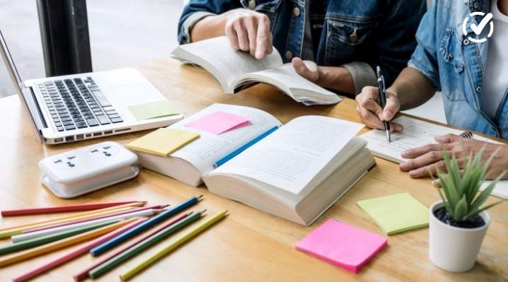 "Two students are seen from the chest up, studying at a wooden table with open books, a laptop, pencils, and sticky notes. The Formative by Newsela logo is in the top right corner."