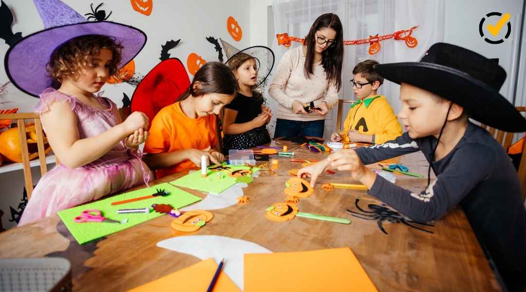 "Three children in Halloween costumes and hats are seated at a table engaged in crafts, while an adult stands in the background supervising. The Formative by Newsela logo is in the top right corner." 