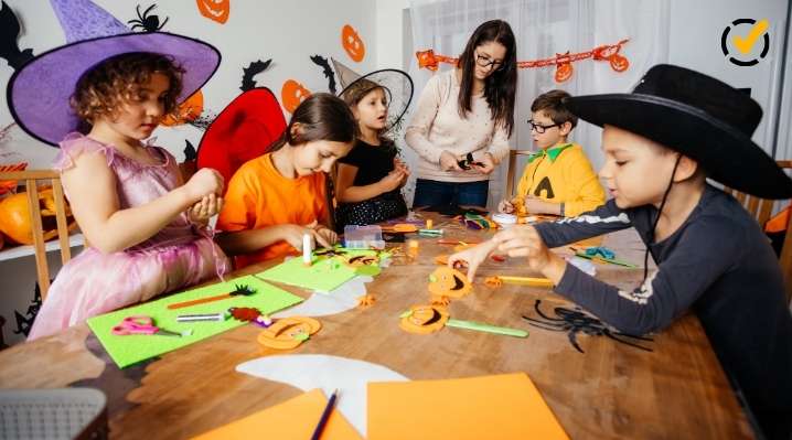 "Three children in Halloween costumes and hats are seated at a table engaged in crafts, while an adult stands in the background supervising. The Formative by Newsela logo is in the top right corner." 