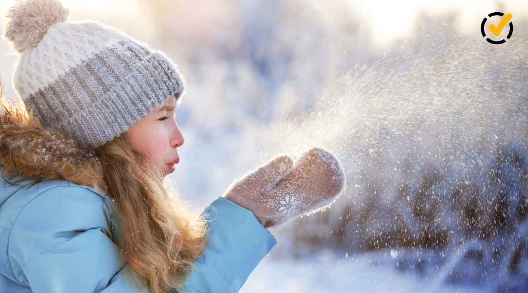 "A young child, bundled in a winter coat, knit hat, and mittens, blows a cloud of snow or frosty breath into the air, illuminated by sunlight against a blurred winter backdrop. The Formative by Newsela logo is in the top right corner."