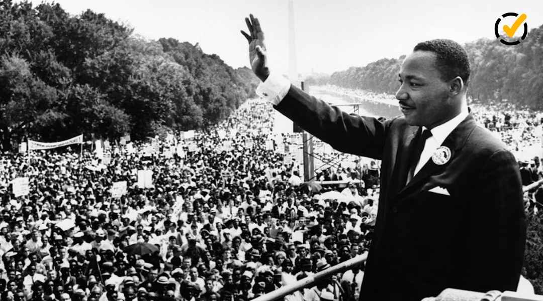 "A black and white photo of Martin Luther King Jr. raising his right hand in a wave to a vast crowd gathered during a civil rights march. The Formative by Newsela logo is in the top right corner. "