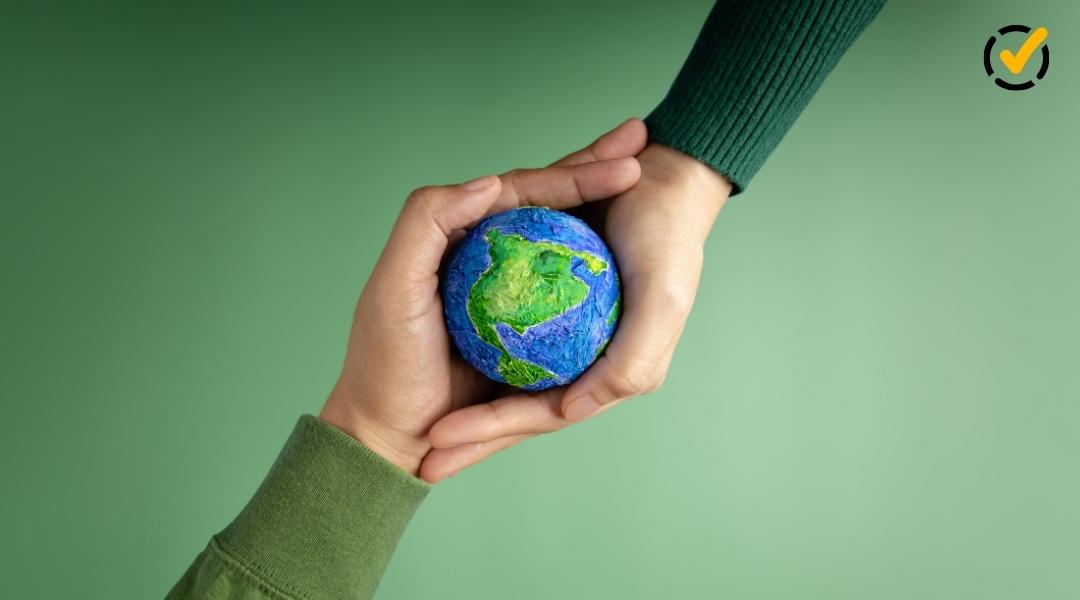 Close-up of two hands holding a small, handmade globe of Earth. The background is a soft green, and the Formative logo appears as a small yellow checkmark icon in the top right corner.