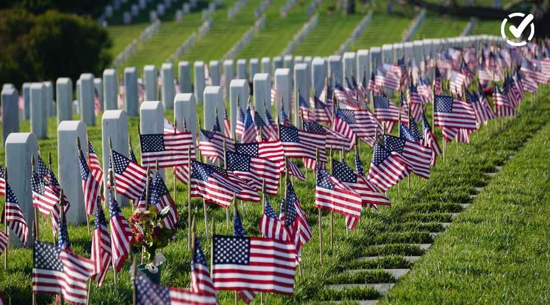 Rows of white marble headstones at a national cemetery decorated with numerous small American flags for Memorial Day; includes a Formative logo in the corner.