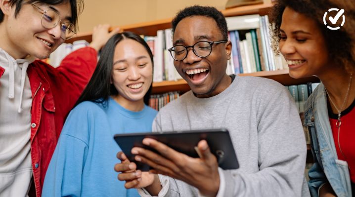 Students laughing while looking at a tablet for Digital Citizenship Week classroom activities