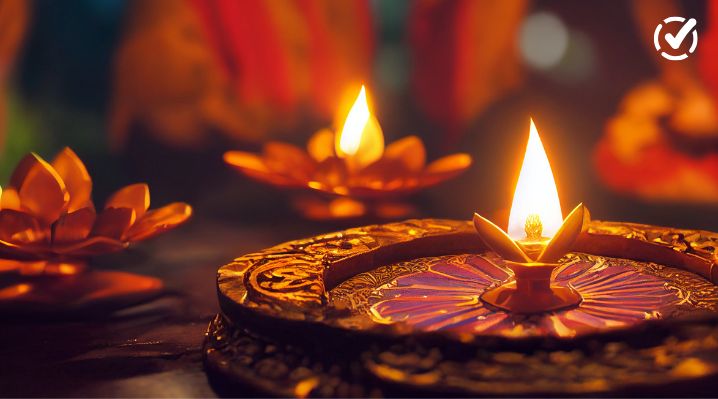 Lit diya oil lamps glow on decorative trays during Diwali, the Hindu festival of lights, symbolizing the triumph of light over darkness.