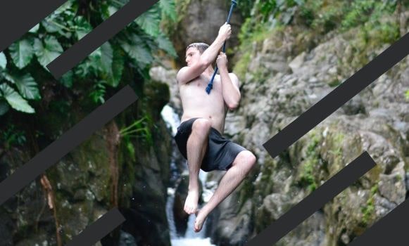 Brendan swinging a rope in front of a waterfall