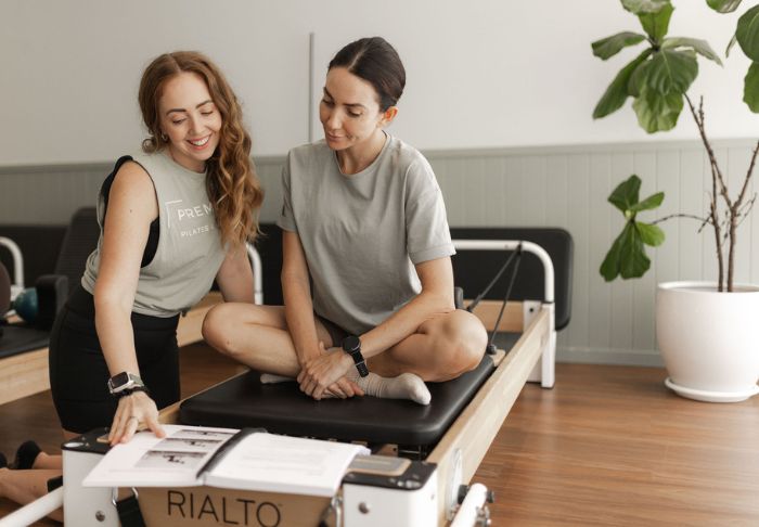 Reformer Pilates instructor teaching theory