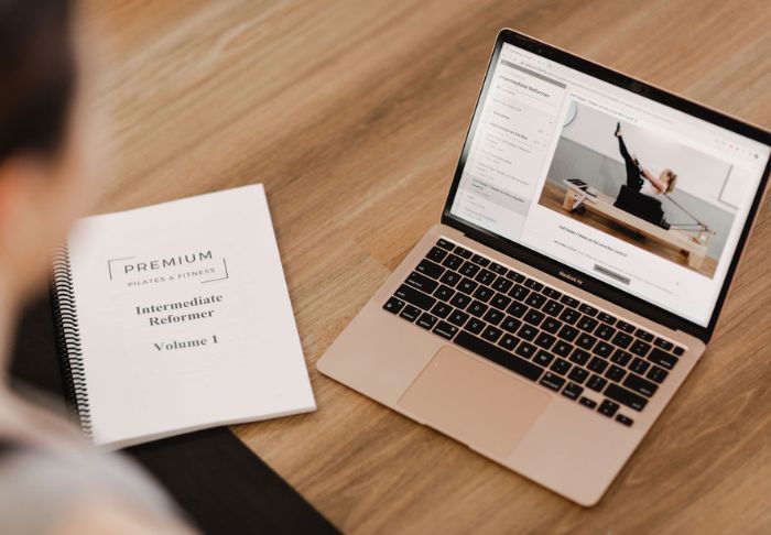 Reformer pilates course guide and laptop