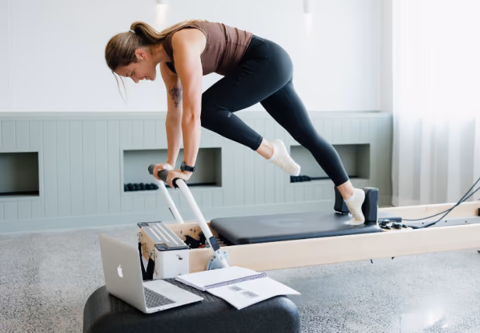 Reformer pilates course guide and laptop