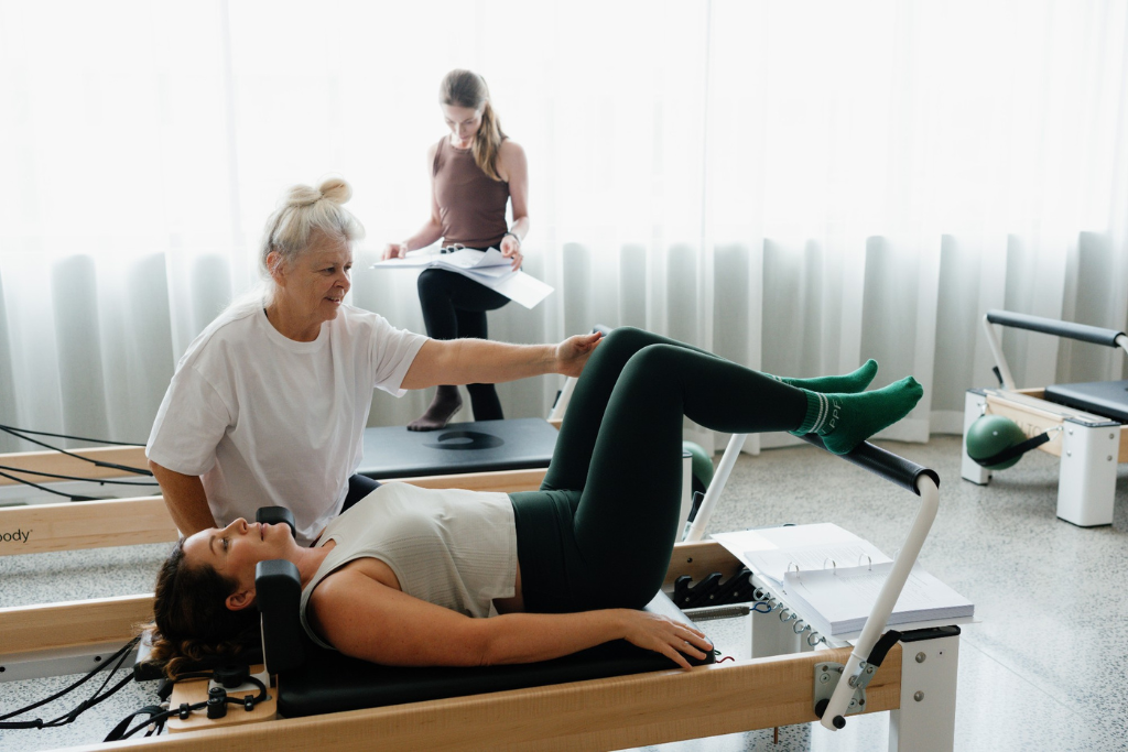 Reformer Pilates instructor teaching theory