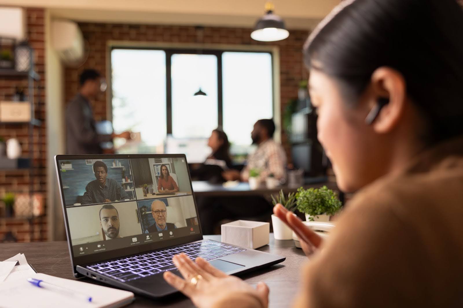 Mulher realizando reunião online com três homens e outra mulher, para definir processos de territorialização.