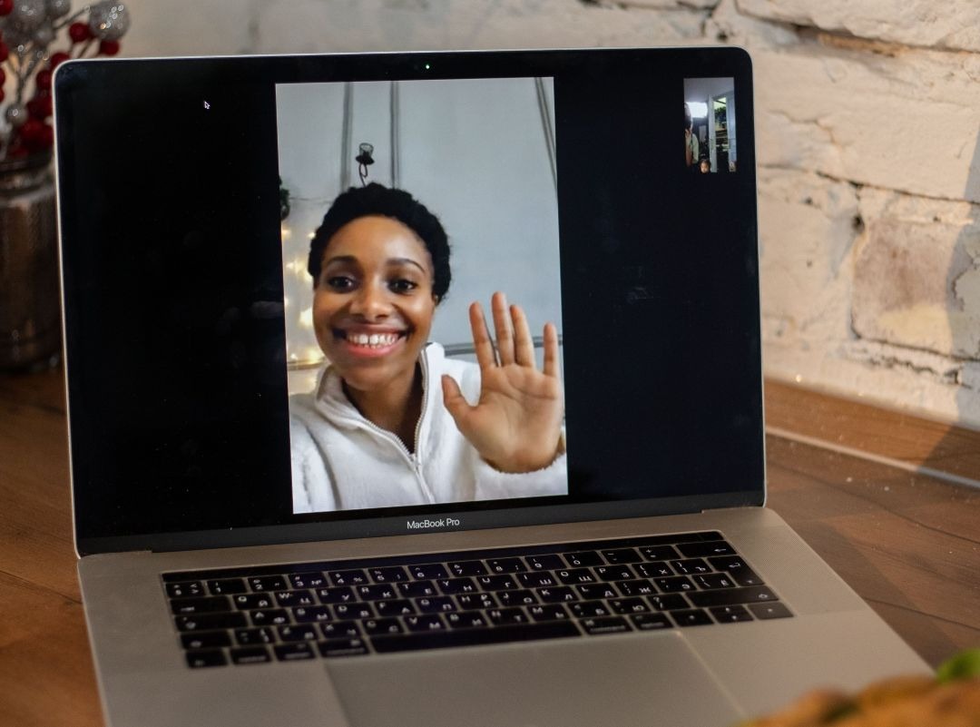  notebook mostrando telechamada, mulher acena durante a terapia online.