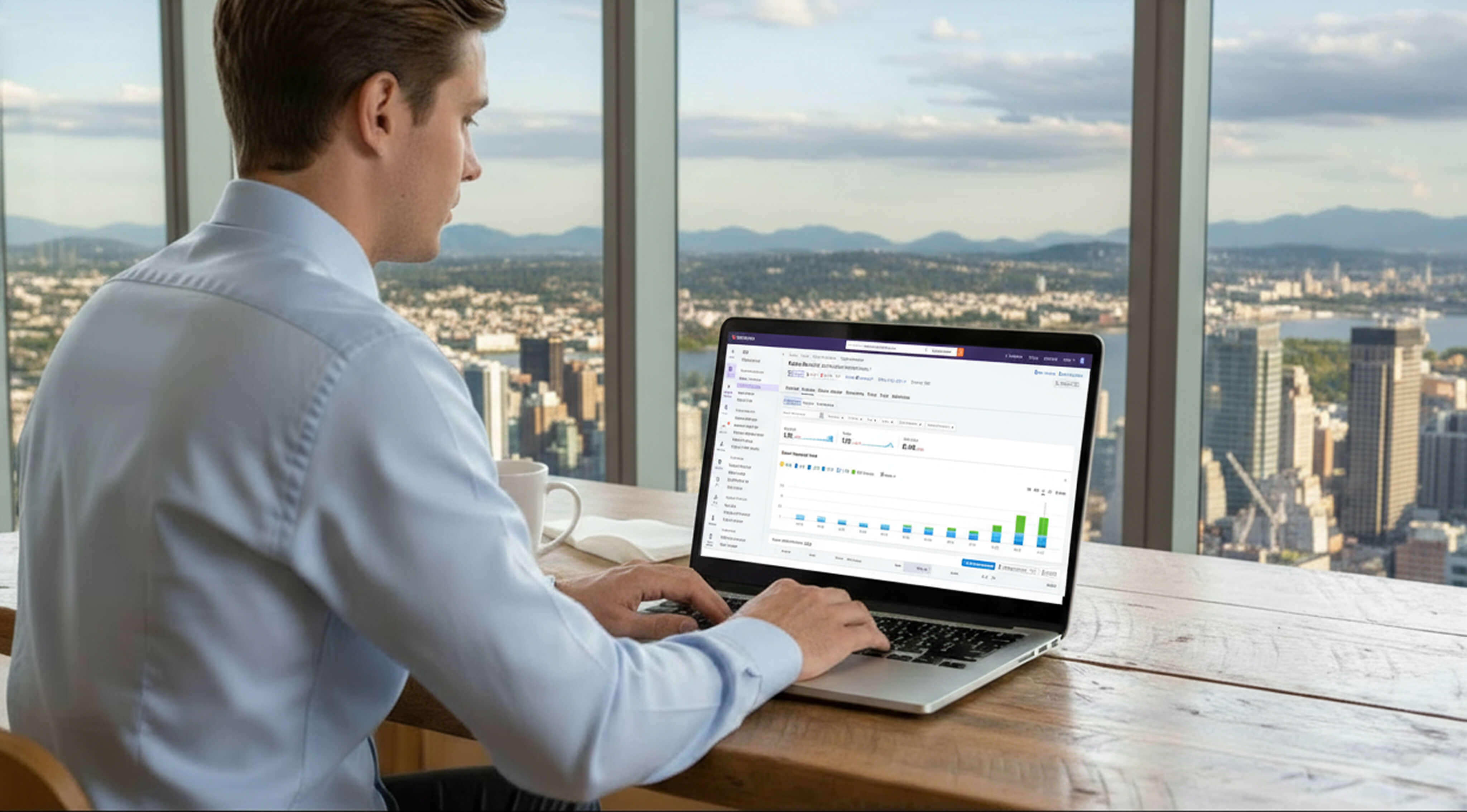 Person analyzing data on a laptop in a high-rise office with a cityscape view in the background.