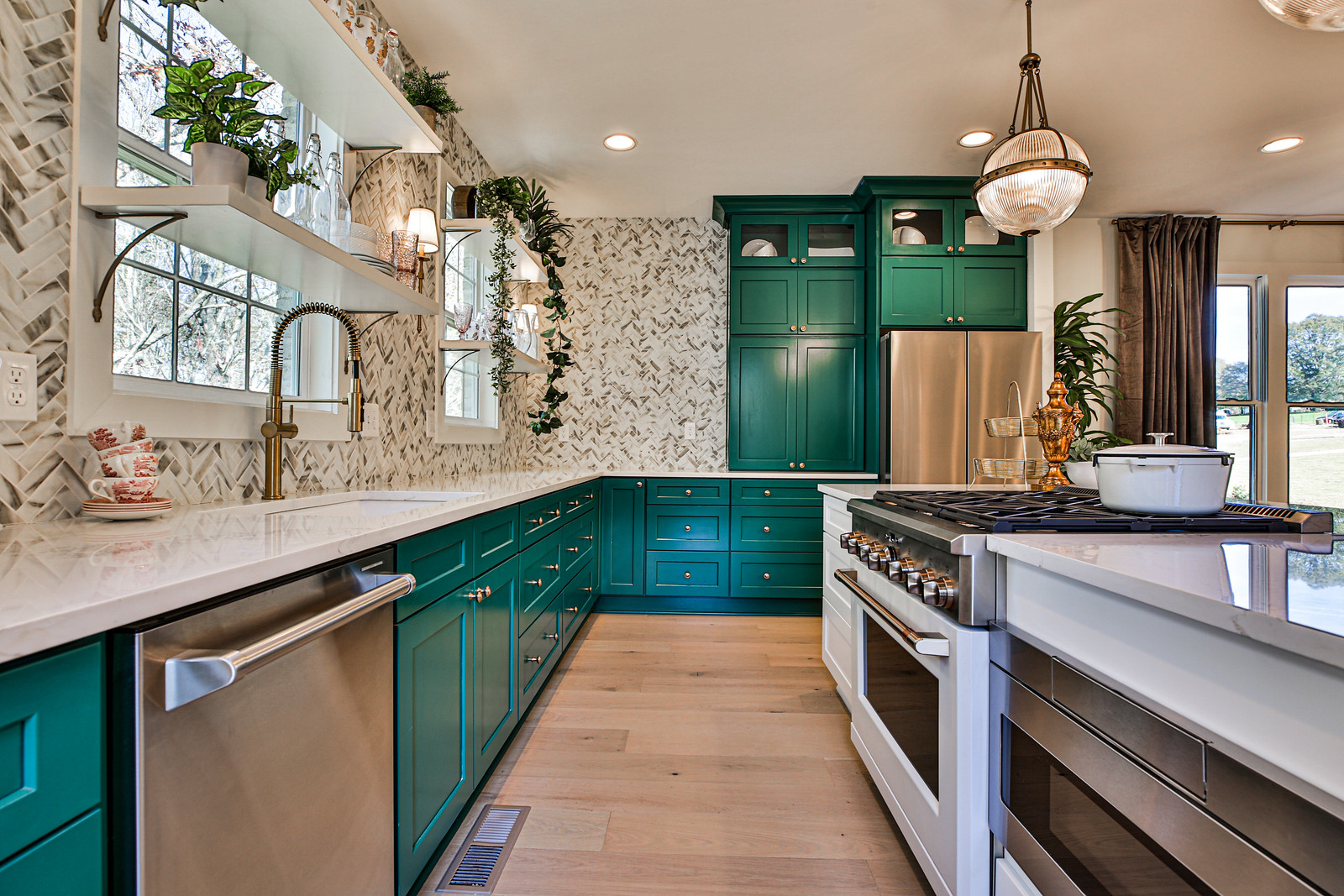 A large modern kitchen with green cabinetry.