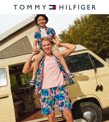 Young man with a boy on his shoulders wearing matching tropical print Tommy Hilfiger clothes