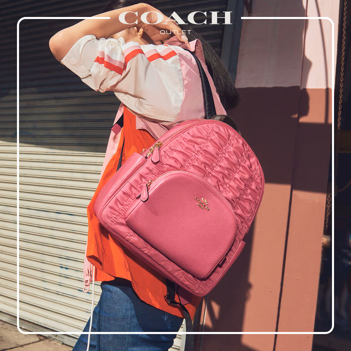 woman wearing denim and a pink monochrome wind breaker holding a watermelon pink coach backpack over her shoulder