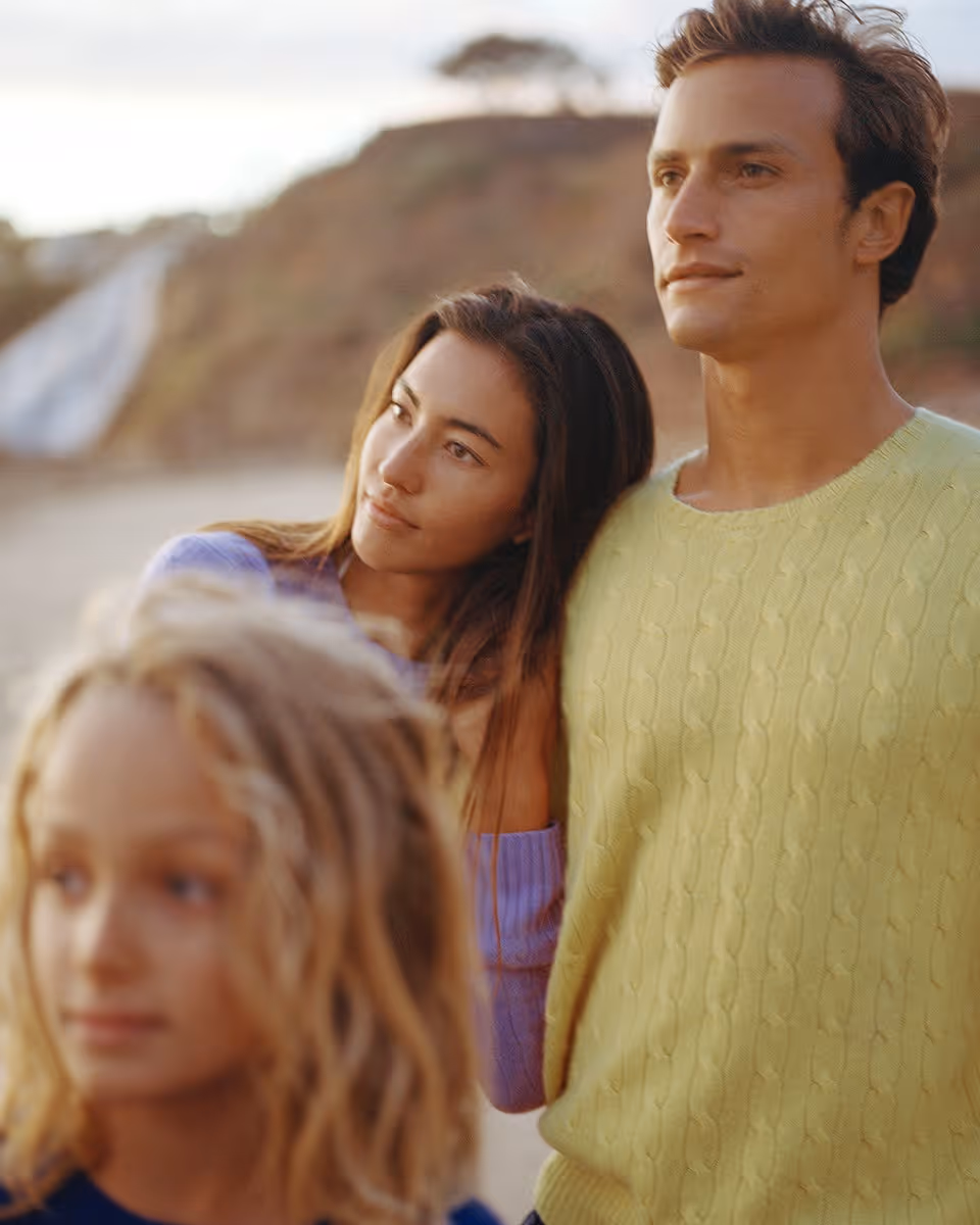 a family looking into the distance wearing polo ralph lauren sweaters at a rocky beachy terrain