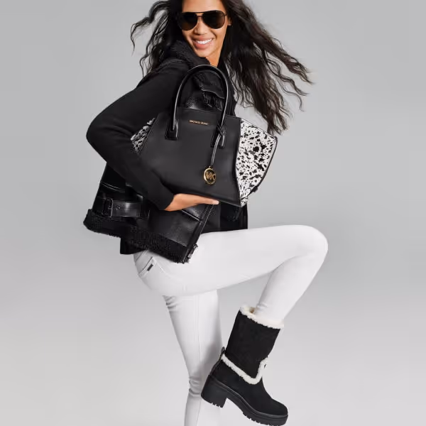 model wearing michael kors black leather jacket boots and white pants 