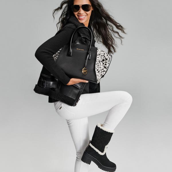 model wearing michael kors black leather jacket boots and white pants 