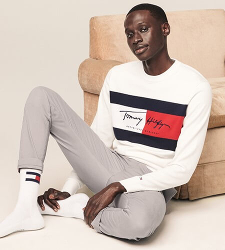 Model wearing white Tommy Hilfiger shirt and gray pants