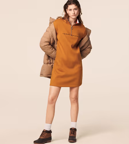 Model wearing a warm brown dress with Tommy Hilfiger on the chest