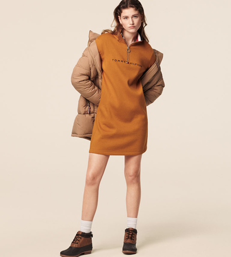 Model wearing a warm brown dress with Tommy Hilfiger on the chest