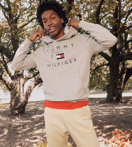 Young man in a grove of trees wearing Tommy Hilfiger sweater